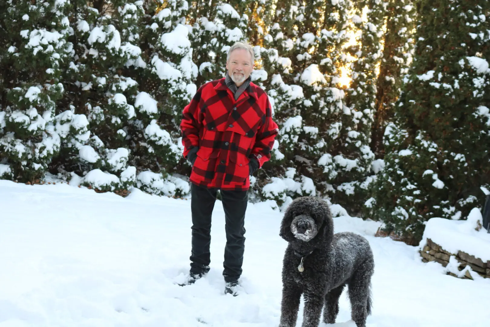 A man and his dog in the snow.