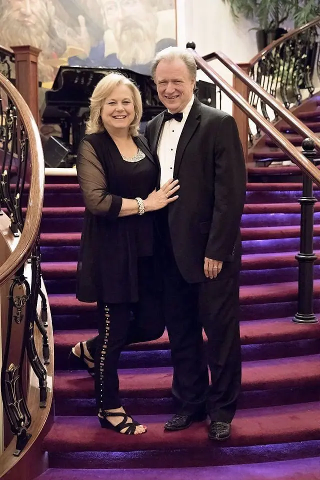 A man and woman posing for a picture on the stairs.