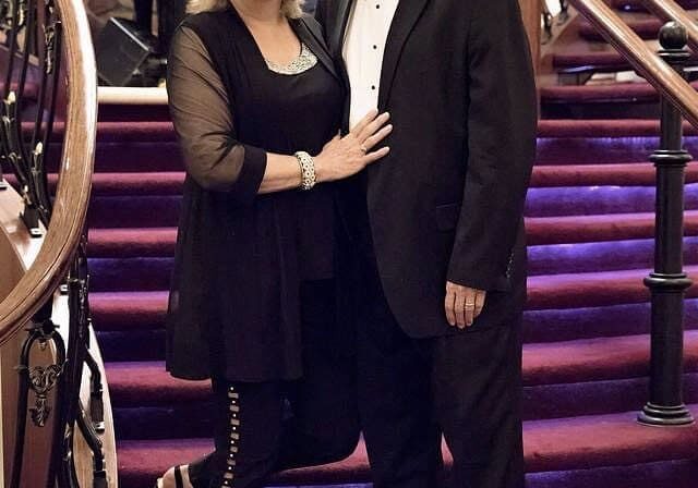 A man and woman posing for a picture on the stairs.