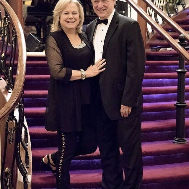 A man and woman posing for a picture on the stairs.